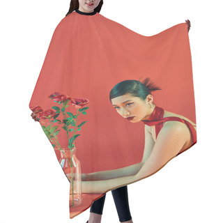 Personality  Young And Elegant Asian Woman In Stylish Neckerchief And Dress, With Bold Makeup And Brunette Hair Laying Near Glass Vase With Roses On Red Background With Lighting, Spring Fashion, Generation Z Hair Cutting Cape