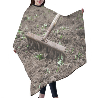 Personality  On The Soil Lie The Garden Rake. Close-up, Concept Of Gardening Hair Cutting Cape