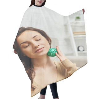 Personality  Portrait Of Pleased Brunette Woman With Closed Eyes In Brown Jumper Massaging Lymphatic Nodes With Manual Massage Ball In Living Room, Lymphatic System Support And Home-based Massage Hair Cutting Cape