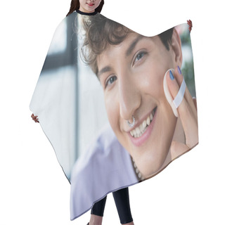 Personality  Portrait Of Smiling Transgender Person With Piercing Applying Face Powder And Looking At Camera  Hair Cutting Cape