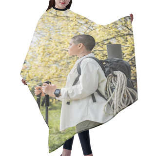 Personality  Side View Of Young Short Haired And Tattooed Female Hiker With Backpack And Climbing Rope Holding Trekking Poles And Walking On Blurred Nature, Independent Traveler Embarking On Solo Journey Hair Cutting Cape