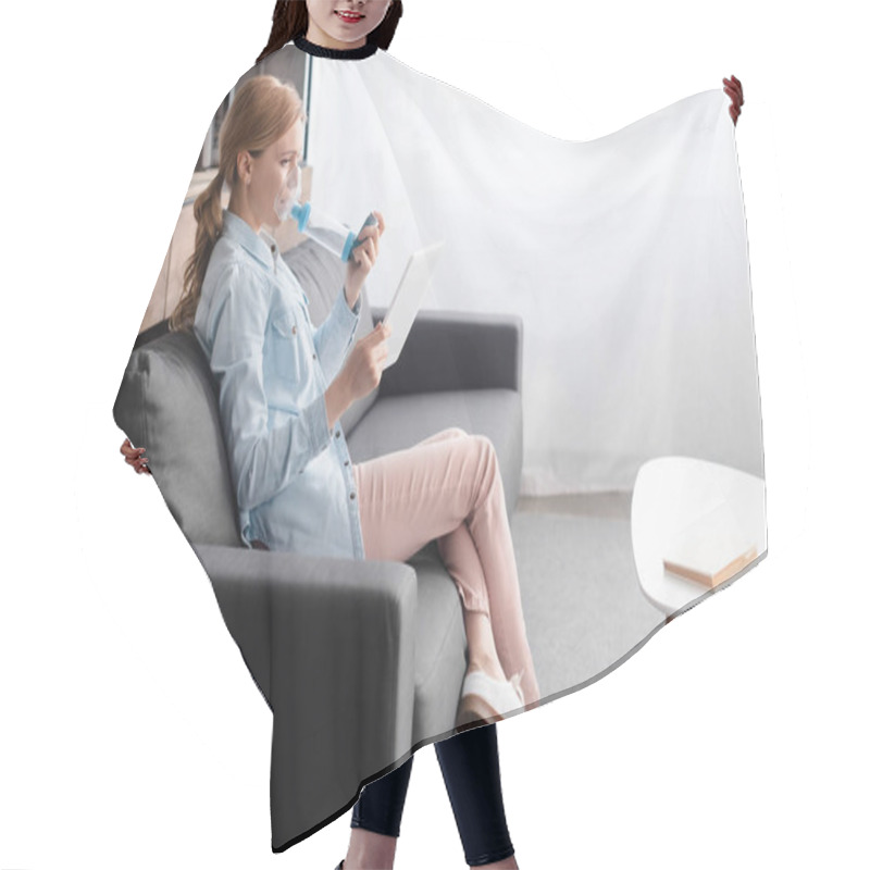 Personality  side view of asthmatic woman using inhaler with spacer and holding digital tablet  hair cutting cape