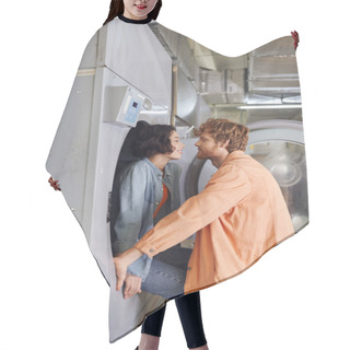 Personality  Side View Of Smiling Asian Woman Sitting On Washing Machine Near Romantic Boyfriend In Coin Laundry Hair Cutting Cape