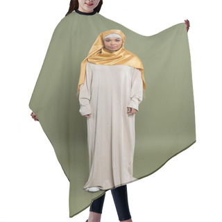 Personality  Full Length Of Multiracial Muslim Woman In Yellow Silk Hijab And Abaya Dress Standing On Olive Green Background Hair Cutting Cape