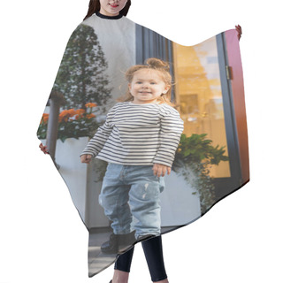 Personality  Joyful Baby Girl In Long Sleeve Shirt And Blue Jeans Standing Near House In Miami  Hair Cutting Cape