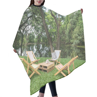 Personality  Relax Wooden Deckchair And Table On Green Grass Yard By Pond With Beautiful Big Trees And Reflection On Water. Outdoor Cafe And Restaurant. Hair Cutting Cape