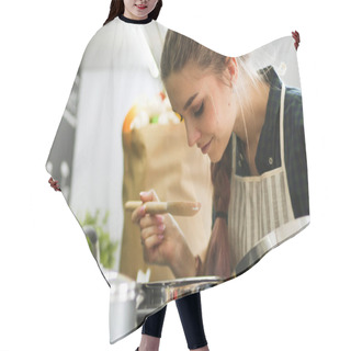 Personality  Young Woman Standing By The Stove In The Kitchen . Hair Cutting Cape
