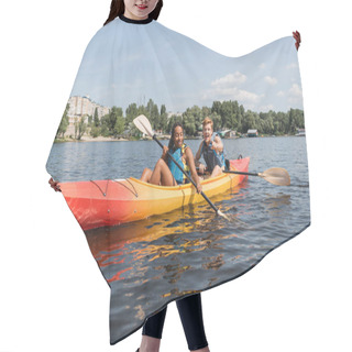 Personality  Young And Happy Redhead Man In Life Vest Pointing With Finger And Paddling In Kayak With Enchanting African American Woman On Lake With Green Shore In Summer Hair Cutting Cape