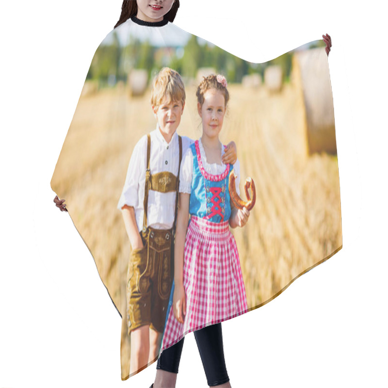 Personality  Two kids, boy and girl in traditional Bavarian costumes in wheat field hair cutting cape