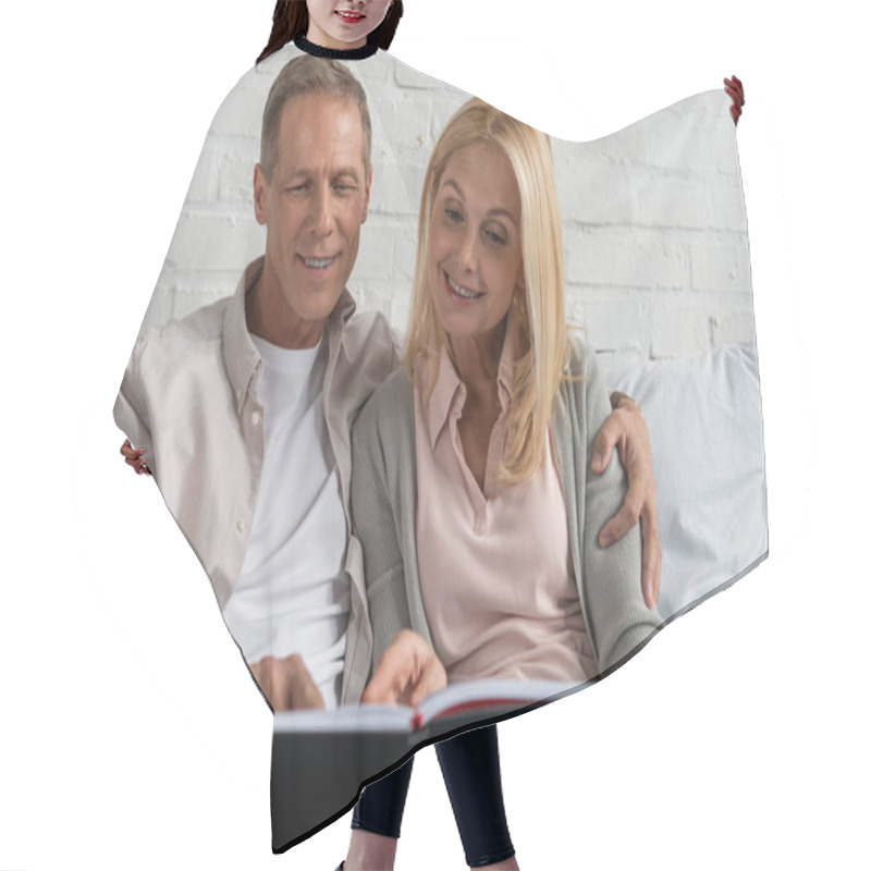 Personality  Smiling Couple Looking At Notebook While Sitting On Bed Hair Cutting Cape