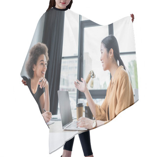 Personality  Asian Businesswoman Talking To Smiling African American Colleague Near Laptop With Blank Screen Hair Cutting Cape