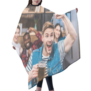 Personality  Excited Young Man Holding Glass Of Beer And Watching Tv With Friends Sitting Behind Hair Cutting Cape