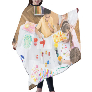 Personality  Overhead View Of Woman Looking At Multicultural Kids Painting On Papers  Hair Cutting Cape