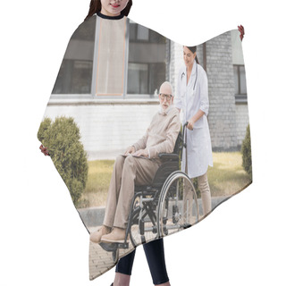 Personality  Smiling Social Worker Walking With Disabled Man In Wheelchair Outdoors Hair Cutting Cape