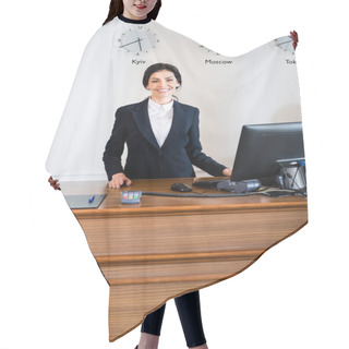 Personality  Cheerful Brunette Receptionist In Formal Wear Standing Near Computer Monitor In Hotel  Hair Cutting Cape