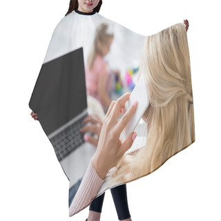 Personality  Woman Talking On Smartphone Near Laptop With Blank Screen And Daughter Playing On Blurred Background Hair Cutting Cape