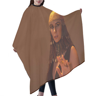 Personality  Woman In Egyptian Headdress And Look Posing At Camera On Brown Background With Light Hair Cutting Cape