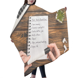 Personality  Cropped View Of Businesswoman Holding Felt-tip Pen Near Notebook With List Of New Years Resolutions Near Laptop, Potted Plant And Wireless Earphones On Wooden Desk Hair Cutting Cape