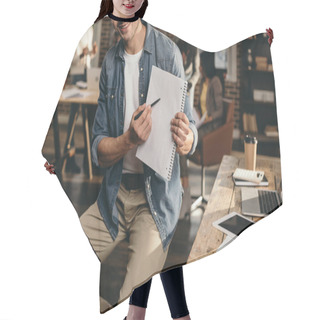 Personality  Cropped View Of Young Man Pointing With Pen On Journal With Colleagues On Background In Modern Loft Office  Hair Cutting Cape