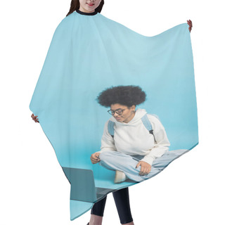 Personality  Full Length Of African American Student In Eyeglasses And White Hoodie Sitting With Crossed Legs Near Laptop On Blue Background Hair Cutting Cape