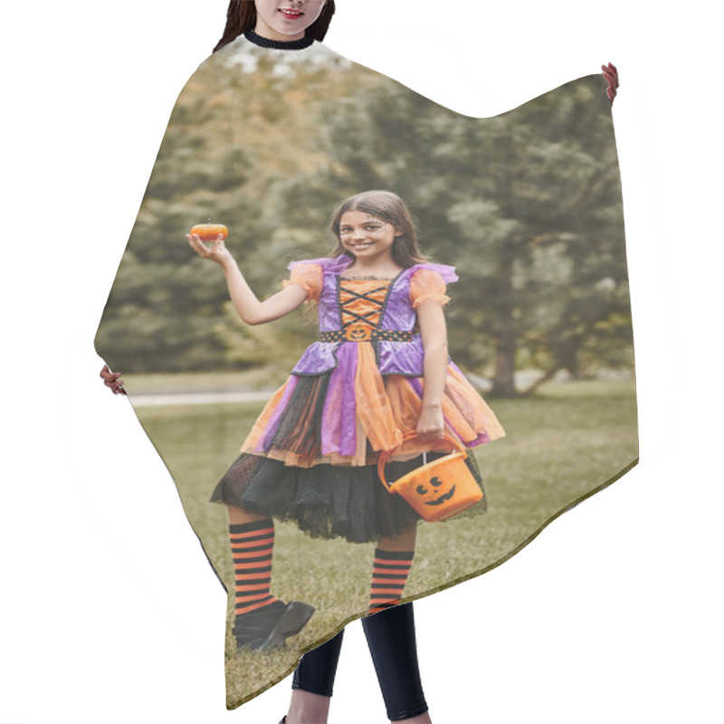 Personality  Cheerful Girl In Halloween Costume Holding Pumpkin And Bucket Of Candies On Green Grass Hair Cutting Cape