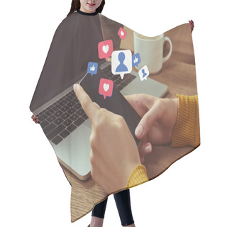 Personality  Cropped Image Of Woman Holding Smartphone With Multimedia Icons At Table With Laptop Hair Cutting Cape