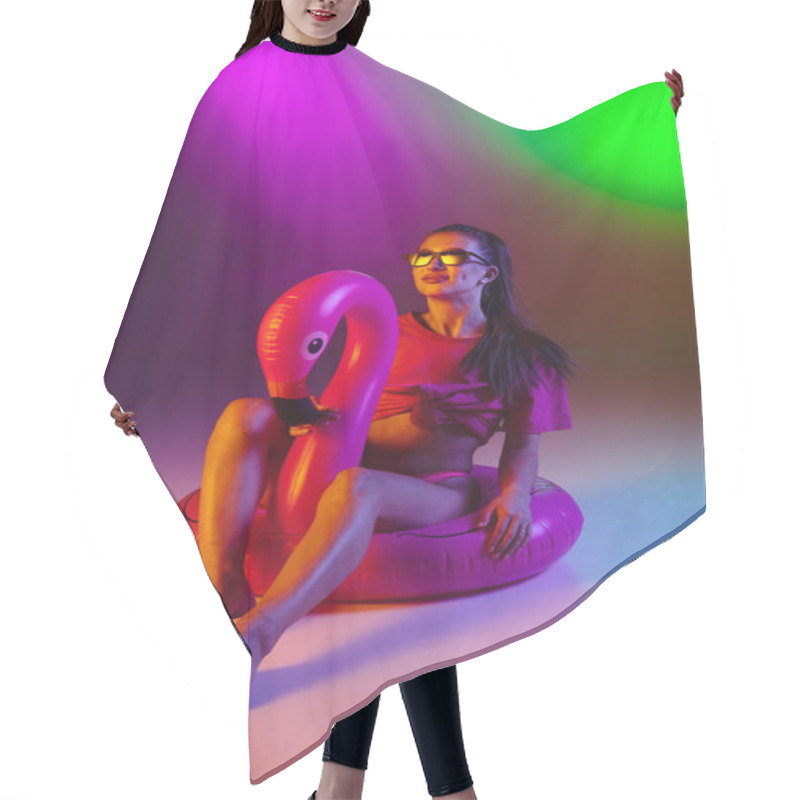 Personality  Beautiful seductive girl in fashionable swimsuit on disco bicolored neon studio background in neon light. Summer, resort, fashion and weekend concept hair cutting cape