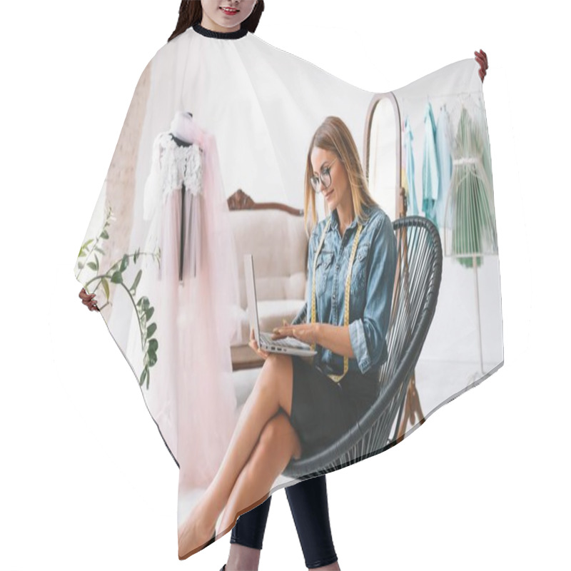Personality  Smiling Fashion Designer Looking At Camera At Workplace, Dressmaker, Needlewoman Or Tailor Shop Owner Sitting At Desk With Color Swatches Pantone And Embroidery Design Sketches On The Wall, Portrait Hair Cutting Cape