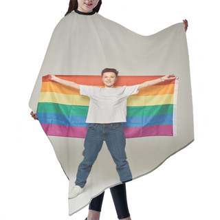 Personality  Full Length Of Redhead Bigender Person In White T-shirt And Jeans Standing With LGBT Flag On Grey Hair Cutting Cape
