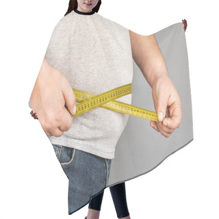 Personality  A Man Measures His Fat Belly With A Measuring Tape. On A Gray Ba Hair Cutting Cape