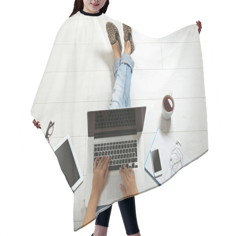 Personality  Top view of young woman sitting on floor with laptop hair cutting cape