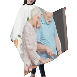Personality  Smiling Senior Woman Standing By Husband Cutting Vegetables On Kitchen Table  Hair Cutting Cape