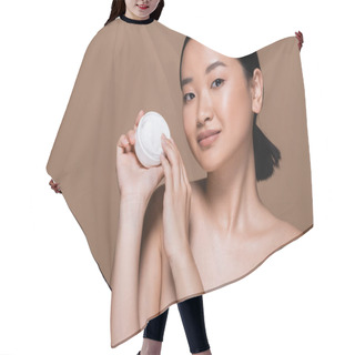 Personality  Pretty Asian Woman With Naked Shoulders Holding Container With Cosmetic Cream Isolated On Brown  Hair Cutting Cape