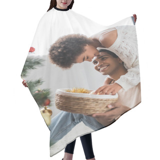 Personality  Cheerful African American Man Holding Wicker Basket Near Young Girlfriend Decorating Blurred Christmas Tree Hair Cutting Cape