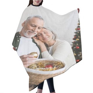 Personality  Smiling Middle Aged Woman Leaning On Husband With Wicker Basket Near Christmas Tree Hair Cutting Cape