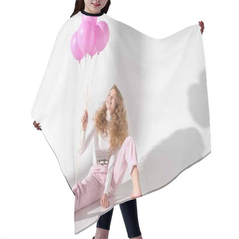 Personality  smiling girl with bundle of pink balloons sitting and looking up hair cutting cape