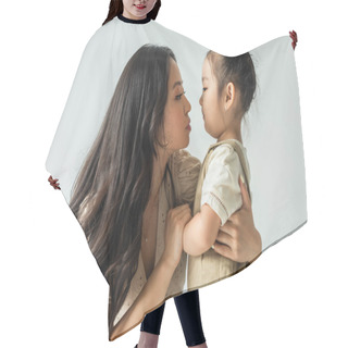 Personality  Side View Of Stylish Asian Mother Hugging Toddler Daughter Isolated On Grey Hair Cutting Cape