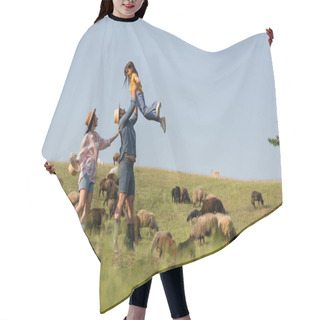 Personality  Side View Of Excited Farmer Holding Daughter Near Wife And Sheep Herd In Green Meadow Hair Cutting Cape