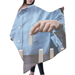 Personality  Cropped View Of Man Picking Wooden Brick Out Of Row On Table  Hair Cutting Cape
