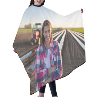 Personality  Female Farmer Standing With Arms Crossed Looking At Camera. Young Farmer Standing In Field With Plant Foil And Tractor Smiling. Hair Cutting Cape