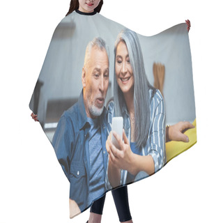 Personality  Cheerful Asian Woman Using Mobile Phone Near Amazed Elderly Husband Hair Cutting Cape