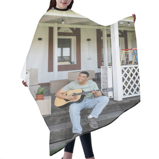 Personality  Cheerful African American Man Playing Acoustic Guitar On Porch Near Boxes And New House Hair Cutting Cape