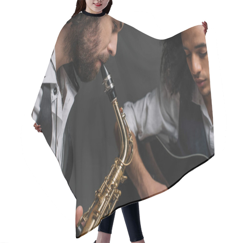 Personality  duet of jazzmen playing sax and acoustic guitar on black hair cutting cape