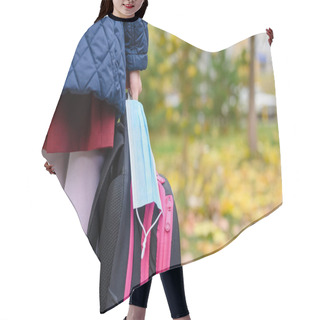 Personality  Medical Mask And Schoolbag In The Hand Of A Schoolgirl. Mask Mode For Schoolchildren During A Pandemic Hair Cutting Cape