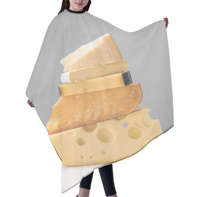 Personality  Close up view of stack of different types of cheese on gray hair cutting cape