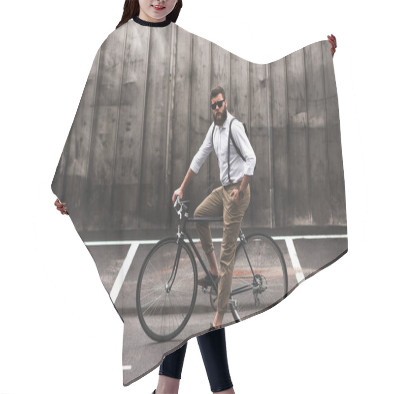 Personality  stylish man sitting on bicycle hair cutting cape