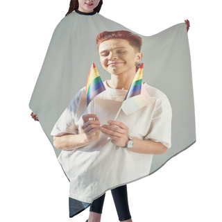 Personality  Redhead Queer Person In White T-shirt Holding Small LGTB Flags And Smiling With Closed Eyes On Grey Hair Cutting Cape