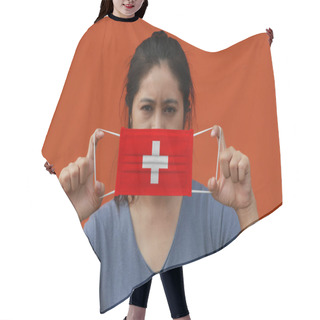 Personality  A Woman With Switzerland Flag On Hygienic Mask In Her Hand And Lifted Up The Front Face On Orange Color Background. Tiny Particle Or Virus Corona Or Covid 19 Protection. Concept Of Combating Illness. Hair Cutting Cape