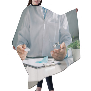 Personality  Cropped View Of Doctor Sitting At Desk And Holding Stethoscope Near Blue Awareness Ribbon Hair Cutting Cape