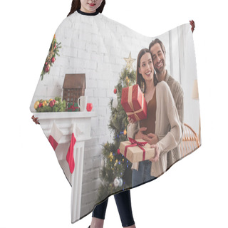 Personality  Happy Man Embracing Wife Holding Gift Boxes Near Christmas Tree And Decorated Fireplace Hair Cutting Cape